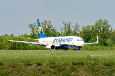 Lublin, Polonya - 05 03 03 2024: Ryanair Boeing 737-800 Ağaçlar ve yeşil alan yakınlarındaki bir pistte.
