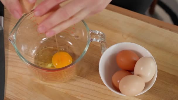 卵子被女孩的手用刀打碎成一个测量杯子 — 图库视频影像