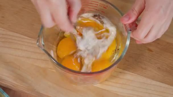 Eier Gewürze Und Milch Werden Mit Einer Mädchenhand Einer Glasschüssel — Stockvideo