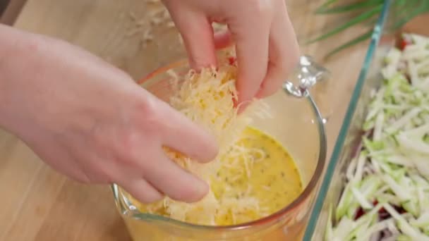 Τριμμένο Τυρί Χύνεται Ένα Μπολ Ανάμιξης Μείγμα Αυγών Χέρια Του — Αρχείο Βίντεο