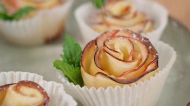 Hamur işleri, elmalı ve nane yapraklı hazır puf börekleri pudra şekerli serpiştirilir. Kamera roketler boyunca sağdan sola hareket eder, ön manzara, yakın çekim.