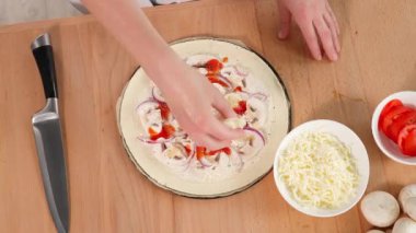 Mantarlı, domates soslu ve soğanlı gerçek pizza, pişirme metodu, aşçı hamurdan gerçek pizza yapar ve pizzanın üzerine mozzarella peyniri serpiştirir. Yakın çekim, üst görünüm