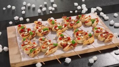 Ahşap bir tahtada, siyah bir arka planda puf börekten yapılmış ahşap bir şiş üzerinde Noel ağacı şeklinde şenlikli bir atıştırmalık. Yakın plan, ön görünüm