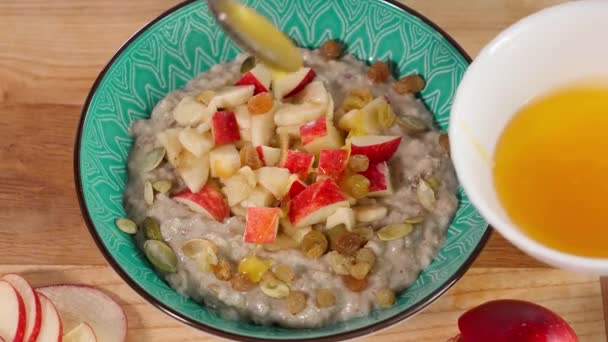 燕麦粥 撒满蜂蜜 与苹果 葵花籽和南瓜籽一起食用 健康早餐 清洁饮食 饮食概念 — 图库视频影像