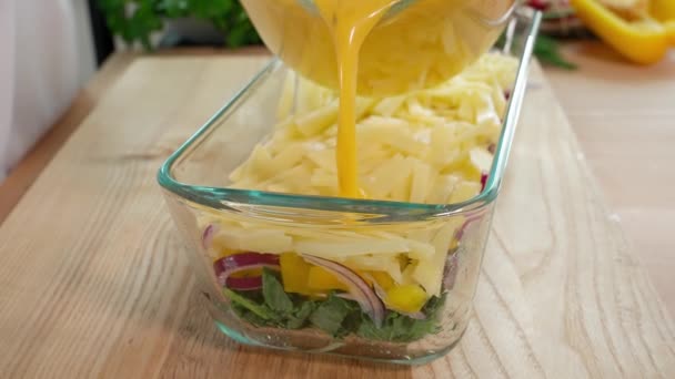 Den Färdiga Äggblandningen Hälls Glasskål Med Grönsaker För Vidare Bakning — Stockvideo