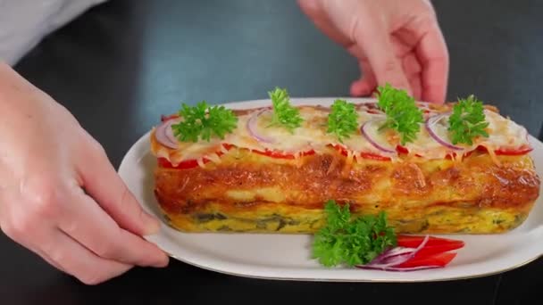 おいしい自家製のシェフの手は トマト パプリカ ほうれん草 チーズ 卵とオムレツのフレーターを披露しています 健康的なベジタリアン料理 伝統的な朝食 クローズアップ — ストック動画