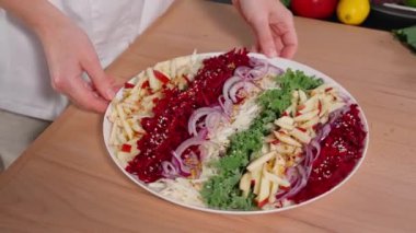 Şef pancar, elma, lahana ve soğan salatası sunar. Fransız hardal sosu, limon suyu ve bal ile tatlandırılmış. Ahşap masa, arka planda sebzeler. Yakın plan, ön görünüm