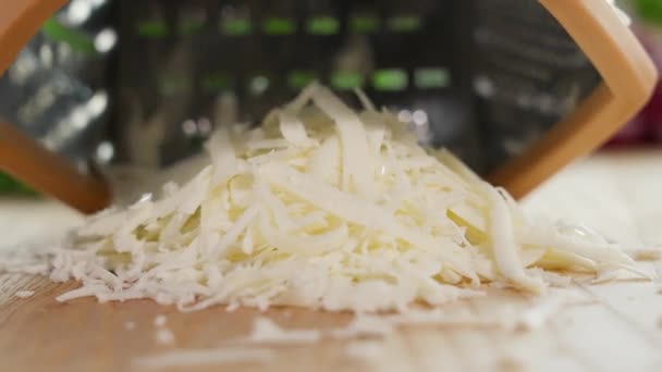 チーズは粗いグレーターに刻まれています クローズアップ マクロ フロントビュー — ストック動画