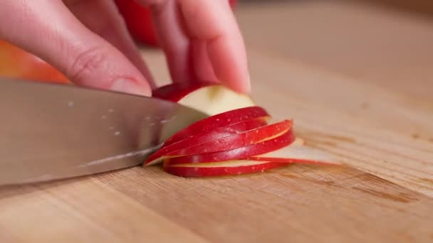 シェフは鋭いナイフを使用して 赤いリンゴを木製の板に薄いスライスに切ります リンゴのデザート 自家製の香りのペストリー クローズアップ マクロ サイドビュー — ストック動画