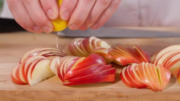 薄いスライスに切られた赤いリンゴは 木製のボードにレモンジュースで注がれます シャーロット パイとリンゴ 自家製の香りのペストリー クローズアップ マクロ フロントビュー — ストック動画