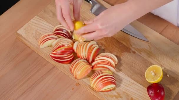 薄いスライスに切られた赤いリンゴは 木製のボードにレモンジュースで注がれます シャーロット パイとリンゴ 自家製の香りのペストリー クローズアップ マクロ トップビュー — ストック動画