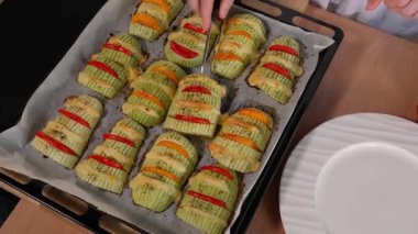 Şef pişmiş kabağı peynir ve domatesle dolu bir tabağa koyar. Kabak aperatifi, kabak akordeonu, kabak tabağı, vejetaryen yemeği, hızlı atıştırma, parti. Yakın çekim, üst görünüm