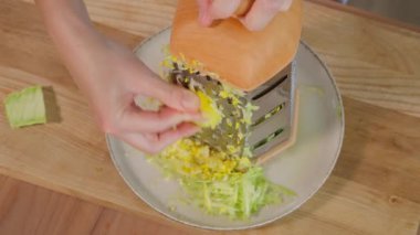 Şef rengarenk kabağı rendelenmiş rende rendeliyor ve sağlıklı bir yemek hazırlıyor. Sağlıklı beslenme konsepti, vejetaryen yemekleri, vitamin zengini sebzeler, diyet. Yakın çekim, üst görünüm