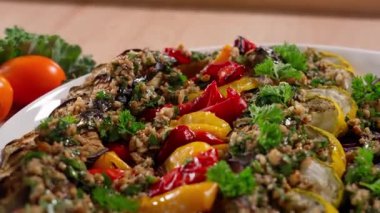 Fırında sebze salatası - patlıcan, kabak, kırmızı biber, soslu soğan. Macro, kamera salatanın üzerinde düzgün hareket ediyor. Aperatif, yemek, sebze salatası, patlıcan tabağı..