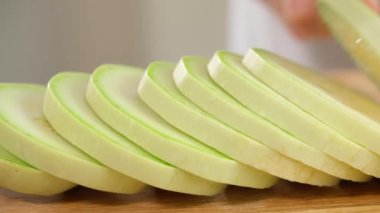 Şef ahşap bir tahtada beyaz kabağı dilimlere ayırır. Sağlıklı beslenme konsepti, vejetaryen yiyecekler, vitamin, diyet ve sebze açısından zengin. Yakın çekim, ön görüş, makro