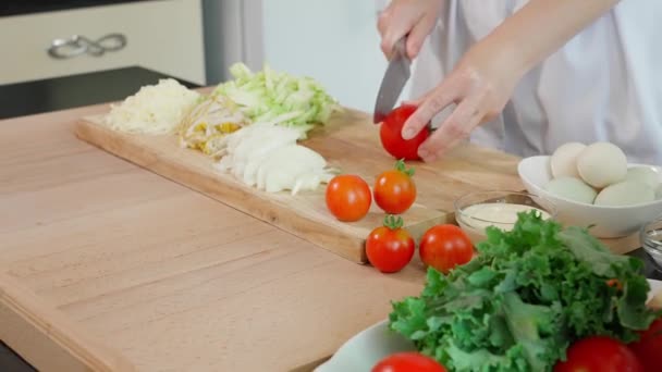 シェフはフリタタを準備しています 鋭いナイフを持つ女性の手は 健康的な食事の概念の背景に スライス 木板にトマトをカットしました クローズアップ フロントビュー — ストック動画