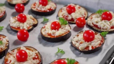 Deko tabağında domates soslu fırında patlıcan, peynir ve vişneli domates, kamera soldan sağa hareket ediyor. Sağlıklı yiyecekler, sebzeler, patlıcan tabakları, fırında patlıcan, atıştırmalık. Makro, üst görünüm