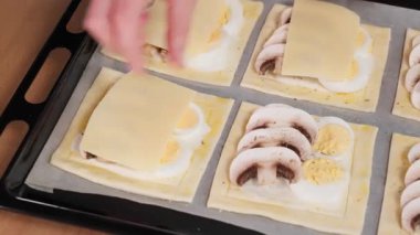 Pişmeden önce mantarlı ve peynirli mini pizzanın yakın çekimi. Mantarlı mini pizza, aperatif, üst manzara, makro