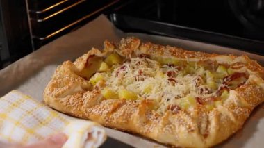 Patates, pastırma ve susamlı peynirli turta pişirmek için fırına gidiyor. Patates tabakları, haşlanmış patatesler, turta doldurma ve atıştırmalıklar. Yakın plan, ön görünüm