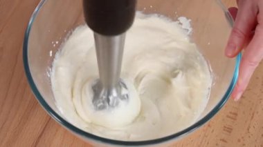 Makro. Krem peynir ve yumurta, pürüzsüz olana kadar cam bir kaseye batırılmış bir blender ile harmanlanır. Panna cotta, krem peynir, hamur işi dolgu, süzme peynir zapikanka. Yakın çekim, üst görünüm