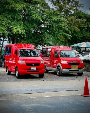Tayland, Phuket 13 Aralık 2024 - İki Tayland geleneksel kırmızı tuk-tuk taksi (songthaew). Kırmızı tuk-tuk taksisi yol boyunca park halinde..
