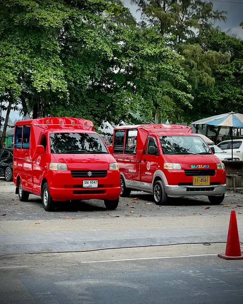 Tayland, Phuket 13 Aralık 2024 - İki Tayland geleneksel kırmızı tuk-tuk taksi (songthaew). Kırmızı tuk-tuk taksisi yol boyunca park halinde..