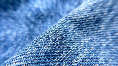 Bulanık kenarlı kot kumaşının detaylı makro görüntüsü. Moda, tekstil, giyim imalatı ve arka planlar için ideal..