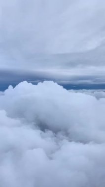 Troposferik seviyede çekilmiş beyaz bulutların görüntüsü. Uçak görülemiyor. Sadece gökyüzü ve bulutlar uçma, özgürlük ve huzur hissi yaratıyor..