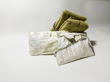 Geleneksel tempeh, beyaz arka planda izole edilmiş meşe yapraklarına sarılmış. Tempeh mayalanmış soyadan yapılan popüler bir Endonezya yemeğidir. Plastiğe sarılmaktan daha lezzetli ve sağlıklıdır..