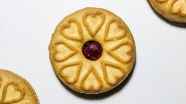 Böğürtlen reçeli dolu süt bisküvileri beyaz arka planda izole edilir. Kalp şeklinde bisküviler. Sevgililer günü kalbi. Üst görünüm.