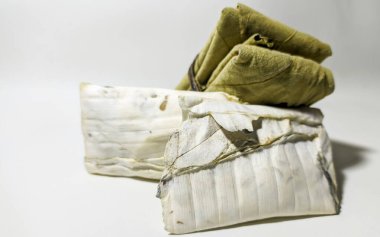 Geleneksel tempeh, beyaz arka planda izole edilmiş meşe yapraklarına sarılmış. Tempeh mayalanmış soyadan yapılan popüler bir Endonezya yemeğidir. Plastiğe sarılmaktan daha lezzetli ve sağlıklıdır..