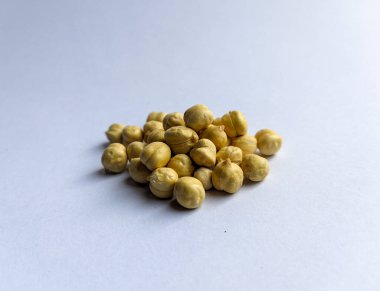 Beyaz arka planda izole edilmiş nohut pişirilmiş. Bir yığın nohut baklası tohumu. Nohut arkaplanını kapat. Nohut tohumu geçmişi. Baklagil tohumları. Yakın plan..