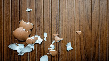 Ahşap bir arka planda kırık yumurta kabuğu. Ahşap dokuda izole edilmiş..