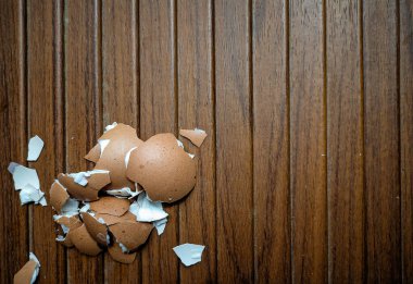 Ahşap bir arka planda kırık yumurta kabuğu. Ahşap dokuda izole edilmiş..