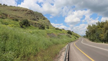 Dağlarda yeşil tarlaları olan bir yol