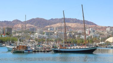 Kızıl Deniz 'de arka planda dağlar olan bir yelkenli.