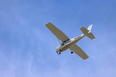 Mavi gökyüzünde uçan beyaz kanatlı beyaz pervane düzlemi