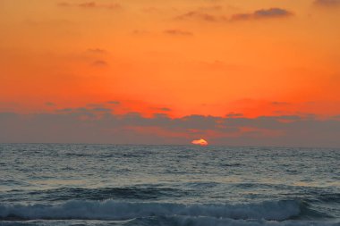 Sahilde güzel bir gün batımı. Denizin üzerinde gün batımı. Güneş denizin üzerinde batıyor..