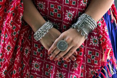 Navratri geleneksel arka planında pembe Dupatta giyen ve oksitlenmiş mücevherler takan bir kadın var. Oksitlenmiş yuvarlak yüzük takıyor. Bunu garba ve dandiya konsepti ya da etkinlikleri için kullanırdı.. 