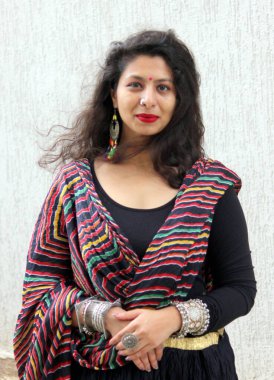 Kırmızı ve çok renkli laheriya desenli dupatta ile Black chaniya choli giyen kadın. Garba ve Dandiya için Navratri festivali modeli. 