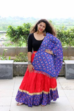 Navratri 'deki Garba ve Daniya festivali için beyaz ve kahverengi Chaniya choli giymiş bir kadın. Manken tarafından giyilen geleneksel Hint kıyafeti. Fişekli etek, dupatta, bluz ve mücevher.