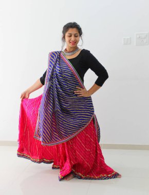 Chaniya 'ya hava atan bir kadın, ghaghra choli. Gujarati, Navratri 'de geleneksel kıyafetler giyen Hintli kadın oksitlenmiş mücevherlerle Garba ve Dandiya oynuyor..