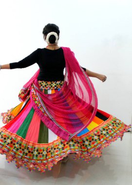 A woman wearing Chaniya choli and the choli is rotating in the air when woman takes round. Traditional attire used with playing Garba and dandiya during navratri in India clipart