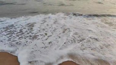 Deniz dalgası kıyılardan geliyor ve kumla karışıyor. Geri dönüşte su denize geri döner ve ıslak kumu ve kuru kumun göz alıcı manzarasını bırakır. Doğa sahili kıyısı su videosu