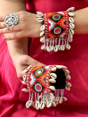 El, canlı işlemeli Navratri kada bileziği takıyor Kodi kabukları ve oksitlenmiş yüzükle süslenmiş, mükemmel bir Hint-batı geleneği ve şenlik zarafeti sergiliyor..