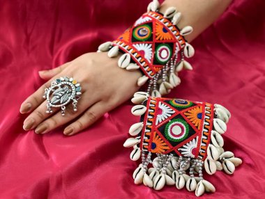 El, canlı işlemeli Navratri kada bileziği takıyor Kodi kabukları ve oksitlenmiş yüzükle süslenmiş, mükemmel bir Hint-batı geleneği ve şenlik zarafeti sergiliyor..