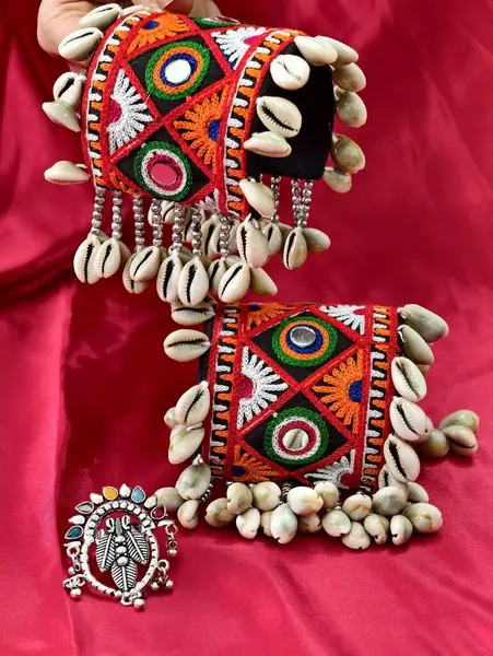El, canlı işlemeli Navratri kada bileziği takıyor Kodi kabukları ve oksitlenmiş yüzükle süslenmiş, mükemmel bir Hint-batı geleneği ve şenlik zarafeti sergiliyor..
