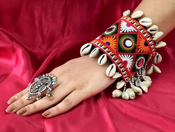 El, canlı işlemeli Navratri kada bileziği takıyor Kodi kabukları ve oksitlenmiş yüzükle süslenmiş, mükemmel bir Hint-batı geleneği ve şenlik zarafeti sergiliyor..