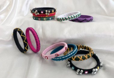 Ayna ve boncuk süslemeli renkli el yapımı bilezikler Navratri şenliği ve kültürel Hindibatı kıyafetleri için canlı desenli geleneksel Hint zanaatkarlığı sergiliyor..