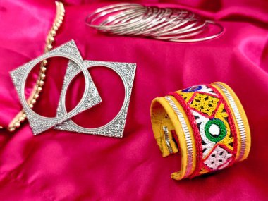 Ayna işi ve iplik işlemeli geleneksel bilezikler oksitlenmiş bileziklerle eşleştirilmiş, Navratri ya da Hindibatı görünümlü. Etnik cazibe ve cesur aksesuarların mükemmel karışımı..